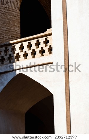 A close-up view of the intricate details of an arch in Iranian architecture. The details are simple yet elegant, with a graceful curve and a subtle pattern. The play of shadows between the details ...