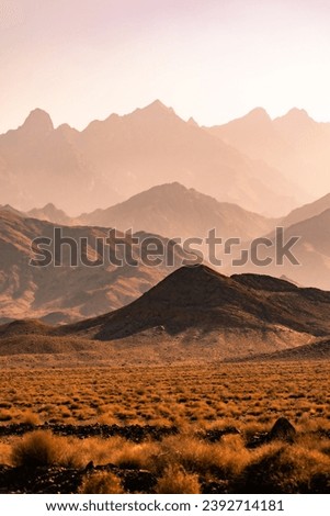 A sweeping vista of the Central Mountains of Iran. The sun-drenched layers of mountains rise up in a majestic array. The shadows cast by the mountains create a sense of depth and dimension ... Royalty-Free Stock Photo #2392714181
