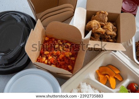 Doggy bags, lunch boxes, and a wide variety of dishes Royalty-Free Stock Photo #2392735883