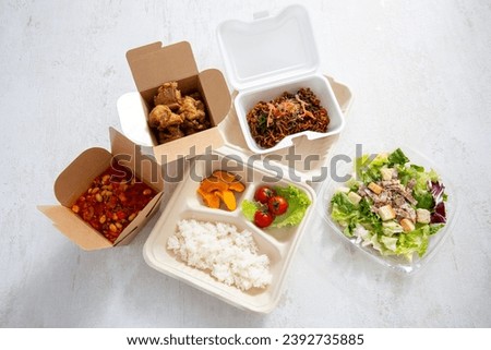 Doggy bags, lunch boxes, and a wide variety of dishes Royalty-Free Stock Photo #2392735885