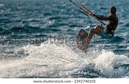 Kitesurfing. Surfers ride the waves of the Mediterranean Sea, performing various tricks. Israel Ashkelon September 9, 2023 Royalty-Free Stock Photo #2392740105