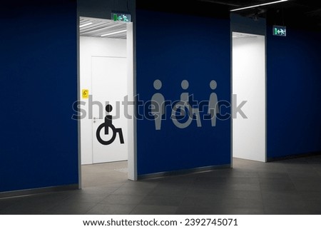 Entrance to the toilet with signs of a man, a woman and a wheelchair. Door to the restroom for people with disabilities