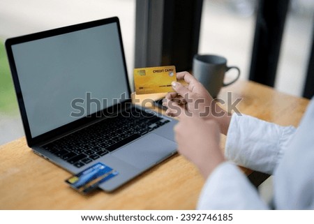Close-up hands holding credit card and using laptop for online shopping. Digital banking and online payment.