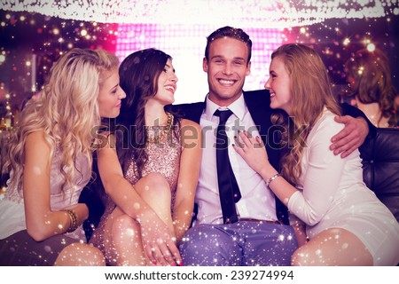 Girls flirting with young man against gold and red lights Royalty-Free Stock Photo #239274994