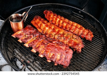 Glasierte Rippchen liegen am Grill - glaced ribs roasting on the grill Royalty-Free Stock Photo #2392754545