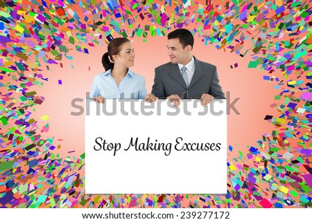 Business partners looking at each other while holding sign together against white card
