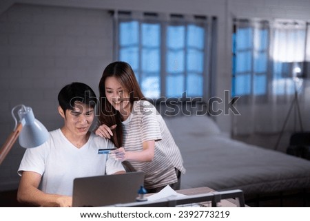 Asian brother and sister gamer add money by credit card in game online payment method and buy rare item collection in Black Friday sale in their bedroom before go to sleep at home Royalty-Free Stock Photo #2392773219