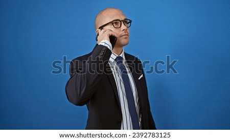 Young hispanic man business worker talking on smartphone over isolated blue background