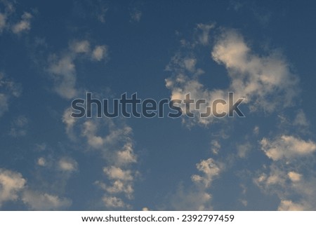 background of pale blue sky, winter blue sky wit wihte clouds, rays of the sun through cirrus pink clouds against the background of the sunset sky	
