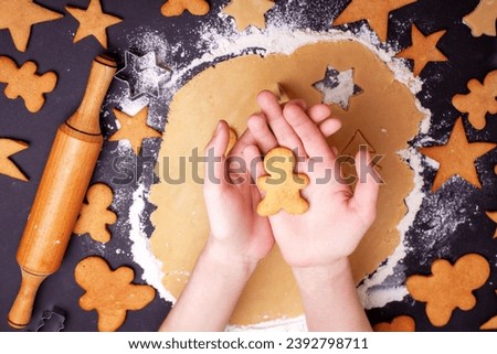 Children's hands hold Christmas gingerbread man cookies. Homemade New Year and Christmas gingerbread