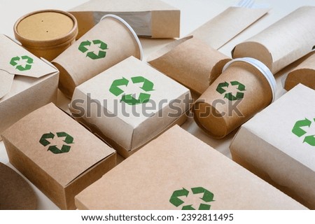 Concept of zero waste recycling and ecology. Disposable food packaging with recycling signs. Angle view, selective focus. Royalty-Free Stock Photo #2392811495