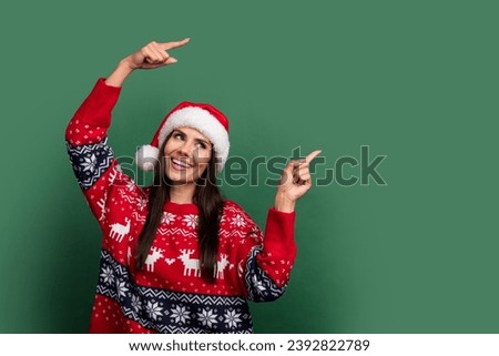 Photo of adorable thoughtful lady santa helper dressed print xmas sweater showing two fingers empty space isolated green color background