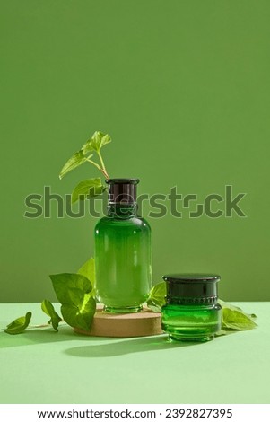 A podium with unbranded bottle standing on displayed with a jar and some leaves. Empty label for cosmetic product mockup of Fish mint (Houttuynia cordata) extracted