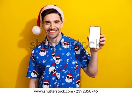 Photo of guy hold christmas product new iphone announcement empty space device touchscreen website app isolated on yellow color background