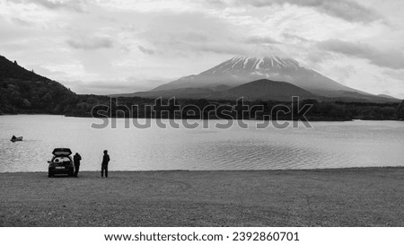 male photographers take picture of lake shoji and mount Fuji near mini suv car, Yamanashi, Japan. Famous travel and camping in 1 of 5 Fuji lakes. Black and white color process.
