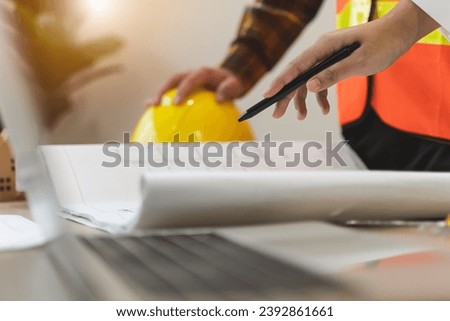 Contractor and client discussing plan of renovating the house and pointing to the laptop computer screen. Royalty-Free Stock Photo #2392861661