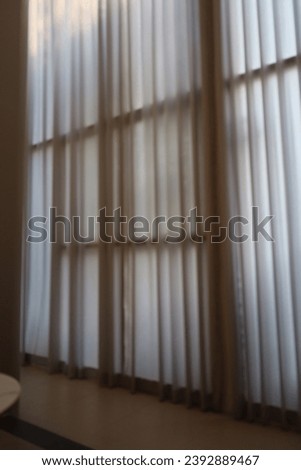 Blur focus of beige background with light and shadow of window curtains