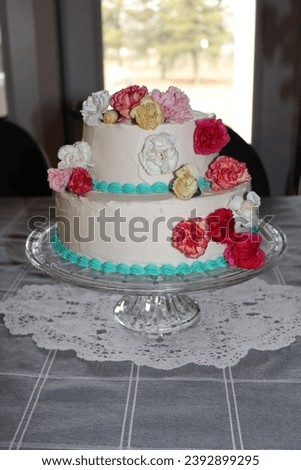 A beautiful decorated two layer cake with flowers on them
