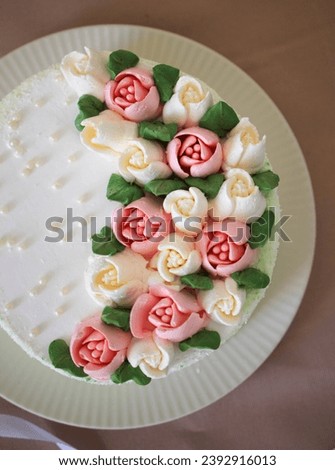 white cake decorated with flowers  on a table. Picture for a menu or a confectionery catalog. Top view.