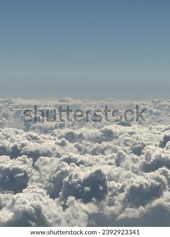 mesmerizing aerial view of clouds from above, revealing a stunning expanse of atmospheric beauty. The interplay of light and shadows creates a dynamic texture,