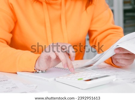 Inflation. Woman uses calculator to calculate expenses for shopping. Receipts and household expenses
