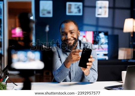 Internet show host being sponsored by partnering brand to do cellphone unboxing content. Technology enthusiast does influencer marketing, doing mobile phone product commercial Royalty-Free Stock Photo #2392957577