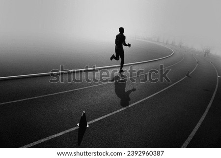 silhouette of a male runner on an athletic field