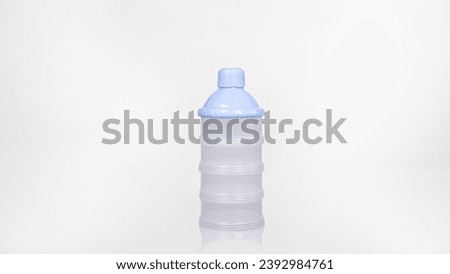 Pictures of cylindrical plastic baby feeding bottles There are 4 alternating layers of raised marks to make it comfortable to hold. With a blue edged milk bottle cap closed.