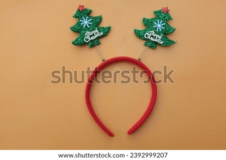 Beautiful headband funny christmas trees isolate on a light orange backdrop.
concept of joyful Christmas party,New year is coming soon, festive season decoration with Christmas elements