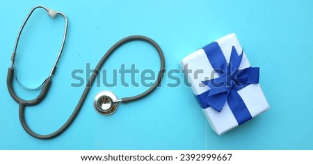 medical stethoscope with gift box isolated on a blue pastel background. concept christmas and new year.horizontal photo