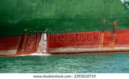 bilge water pumped out of the side of a Cargo Container ship.  Royalty-Free Stock Photo #2393010719