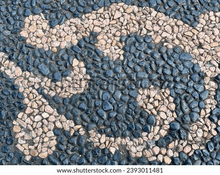 Multi colored pebbles design imbedded in concrete pavement