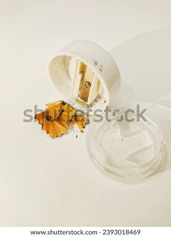 white and clear sharpener with dust from wooden pencil