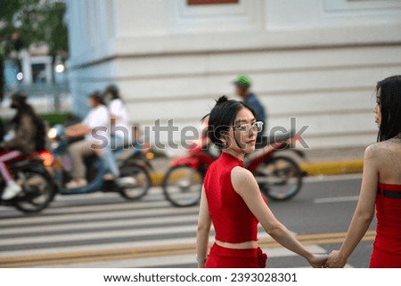 High-quality, free stock photo Two fashionable Asian Vietnamese girls wearing a red dress is walking down the street, representing the energetic youth. Advertisements for products
