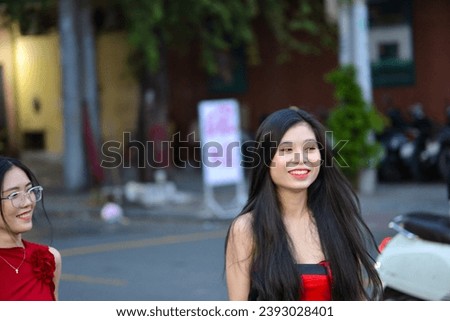 High-quality, free stock photo Two fashionable Asian Vietnamese girls wearing a red dress is walking down the street, representing the energetic youth. Advertisements for products
