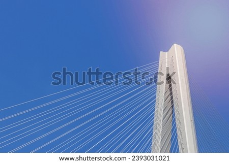 modern bridge background, cable-stayed bridge close-up, main tower and cable against a blue sky Royalty-Free Stock Photo #2393031021