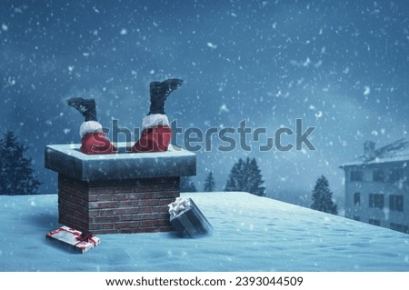 Funny Santa Claus stuck with feet up in a chimney on a roof, he is delivering gifts on Christmas Eve Royalty-Free Stock Photo #2393044509
