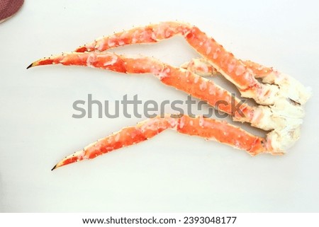 frosted Alaska king crab legs close up photo on white table background
