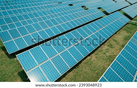 Aerial shot of solar panels farm on the green field. Renewable alternative green energy concept.