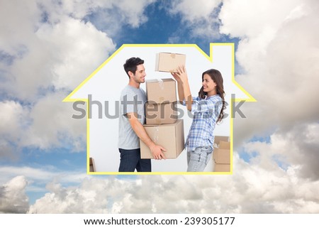 Woman giving boxes to her husband while they are moving against blue sky with white clouds