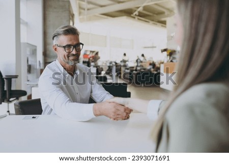 Adult man customer male buyer client wearing shirt consulting with salesman shake hands choose auto want to buy new automobile in car showroom vehicle salon dealership store motor show. Sales concept Royalty-Free Stock Photo #2393071691