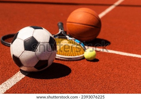 A group of sports equipment on black background including tennis, basketball, and soccer and boxing equipment on a background with copy space Royalty-Free Stock Photo #2393076225