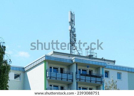 base station tower of a cellular network on the top of a residential building Royalty-Free Stock Photo #2393088751