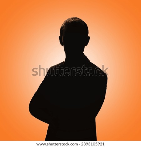 Silhouette of a man. Man posing in a suit on an orange background