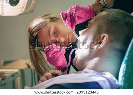 the dentist cleans the root of the patient's tooth by filling the root with gutta-percha. focus on dental gutta-percha Royalty-Free Stock Photo #2393123445
