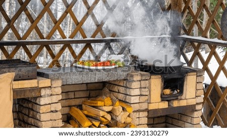Summer veranda with a large stone stove with a cast - iron cauldron . A place for cooking delicious food. Background picture.