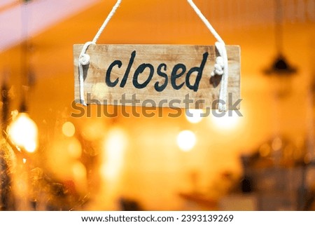 closed sign wooden board hanging on door of cafe