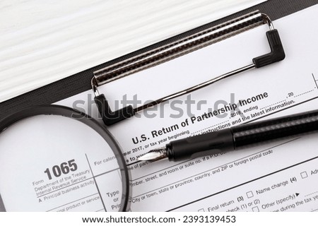 IRS Form 1065 US Return of Partnership Income blank on A4 tablet lies on office table with pen and magnifying glass close up Royalty-Free Stock Photo #2393139453