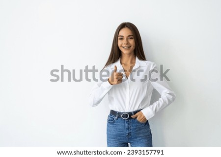 Closeup portrait of a beautiful young woman showing thumbs up sign. Isolate over white background.