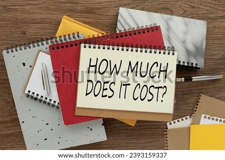 How Much Does it Cost. Business concept. Top view, empty notepad and stationery on the table.
